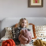 Little Girl on bed with toys