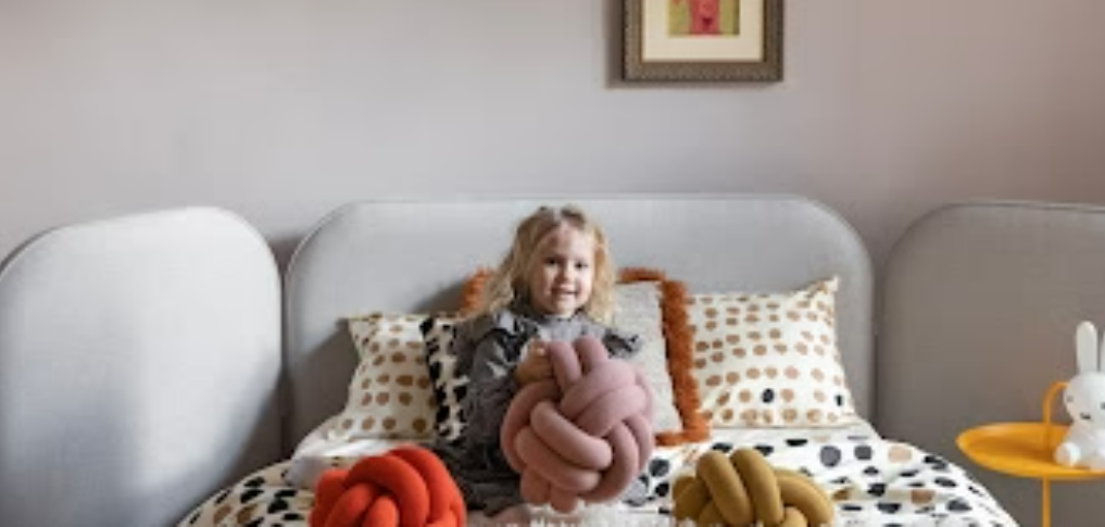 Little Girl on bed with toys