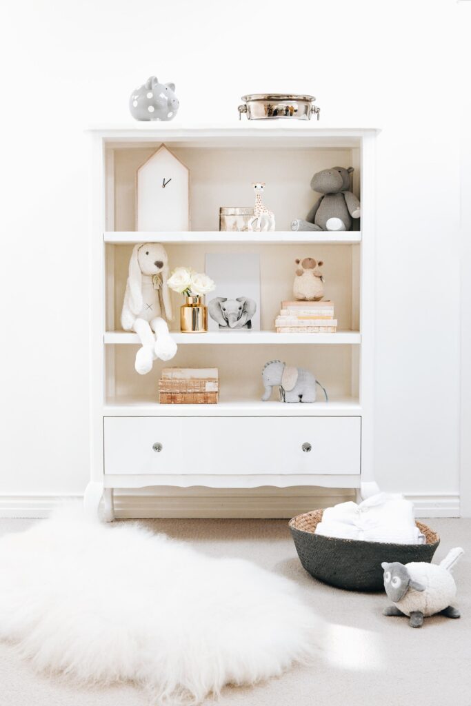 White Isabella Bookshelf styled in a neutral nursery with plush toys and baby accessories