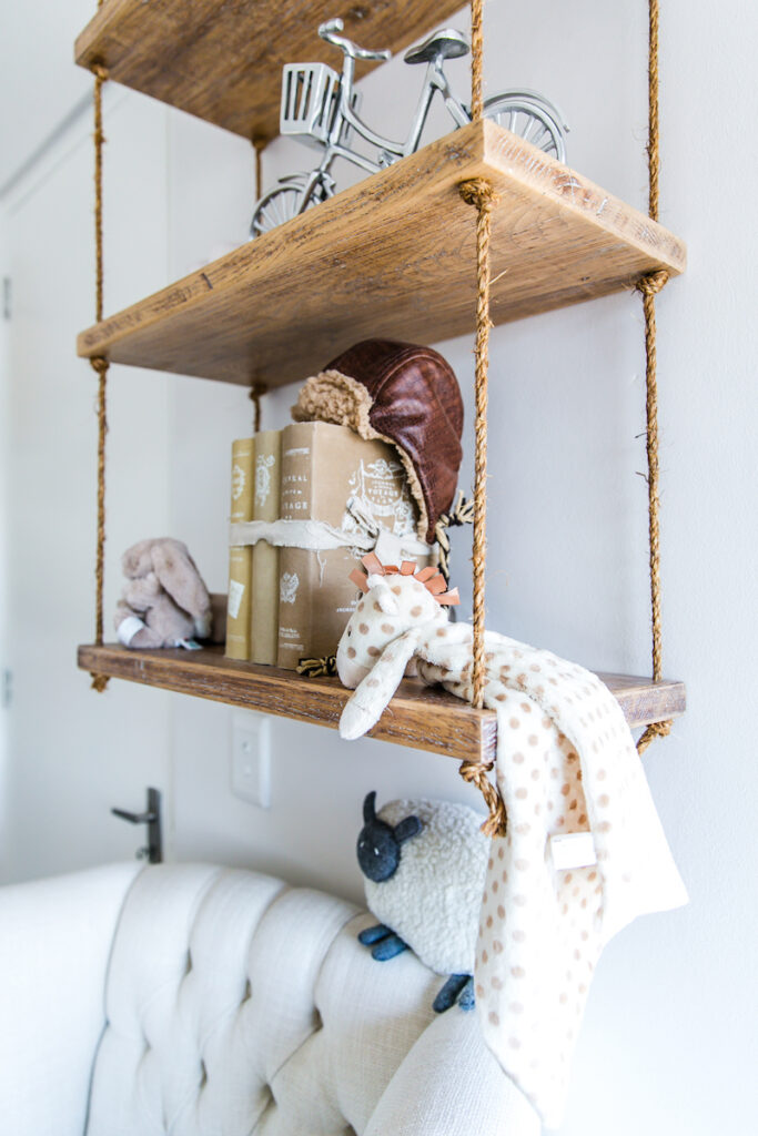 Close-up of vintage-styled Sebastian Rope Shelf with aviator cap, antique books, and plush toys in Baby Belle founder’s nursery